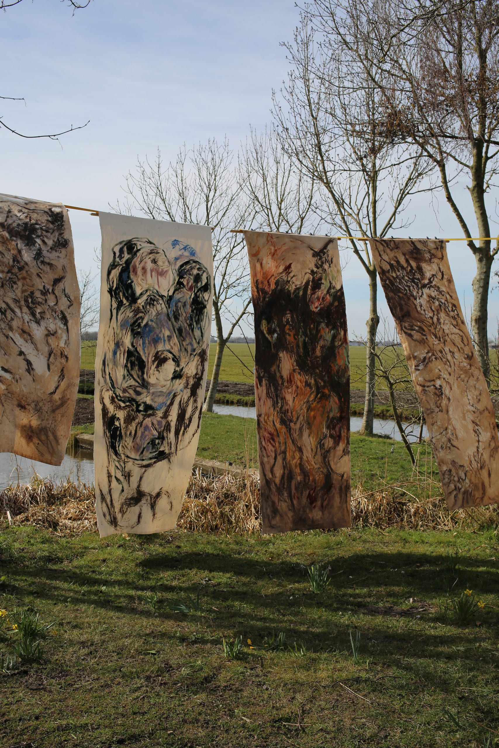 4 tapestries hanging over grass field in the Netherlands