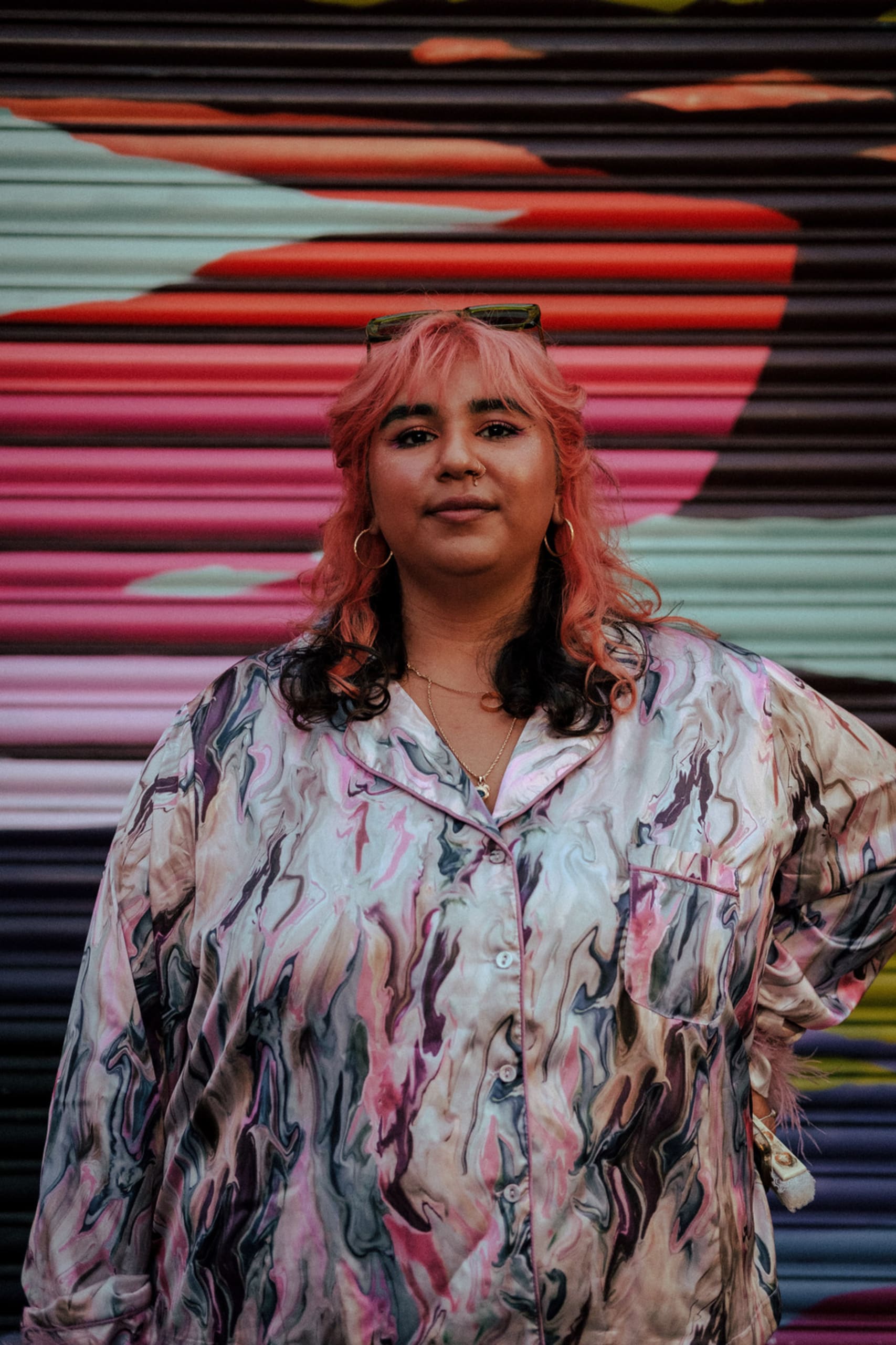 A photograph of a brown fat woman with peach hair wearing a lilac marbled button down top.

@joelindsayphoto