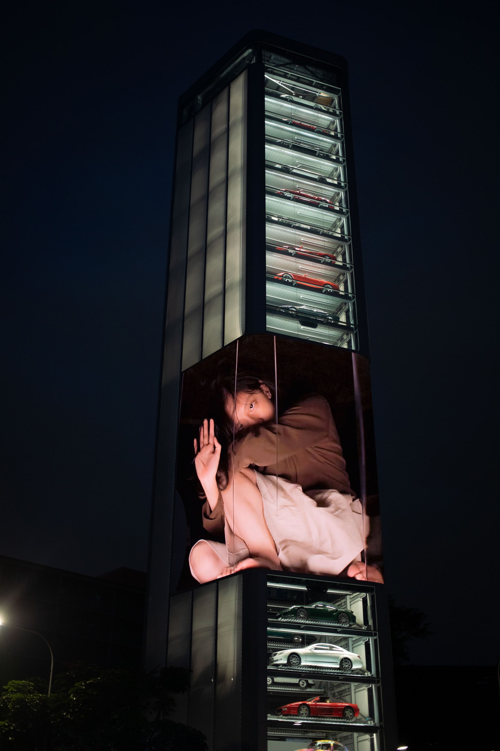 A giant human trapped inside a box on a large LED screen on a tall building in Singapore (from intended viewing angle)