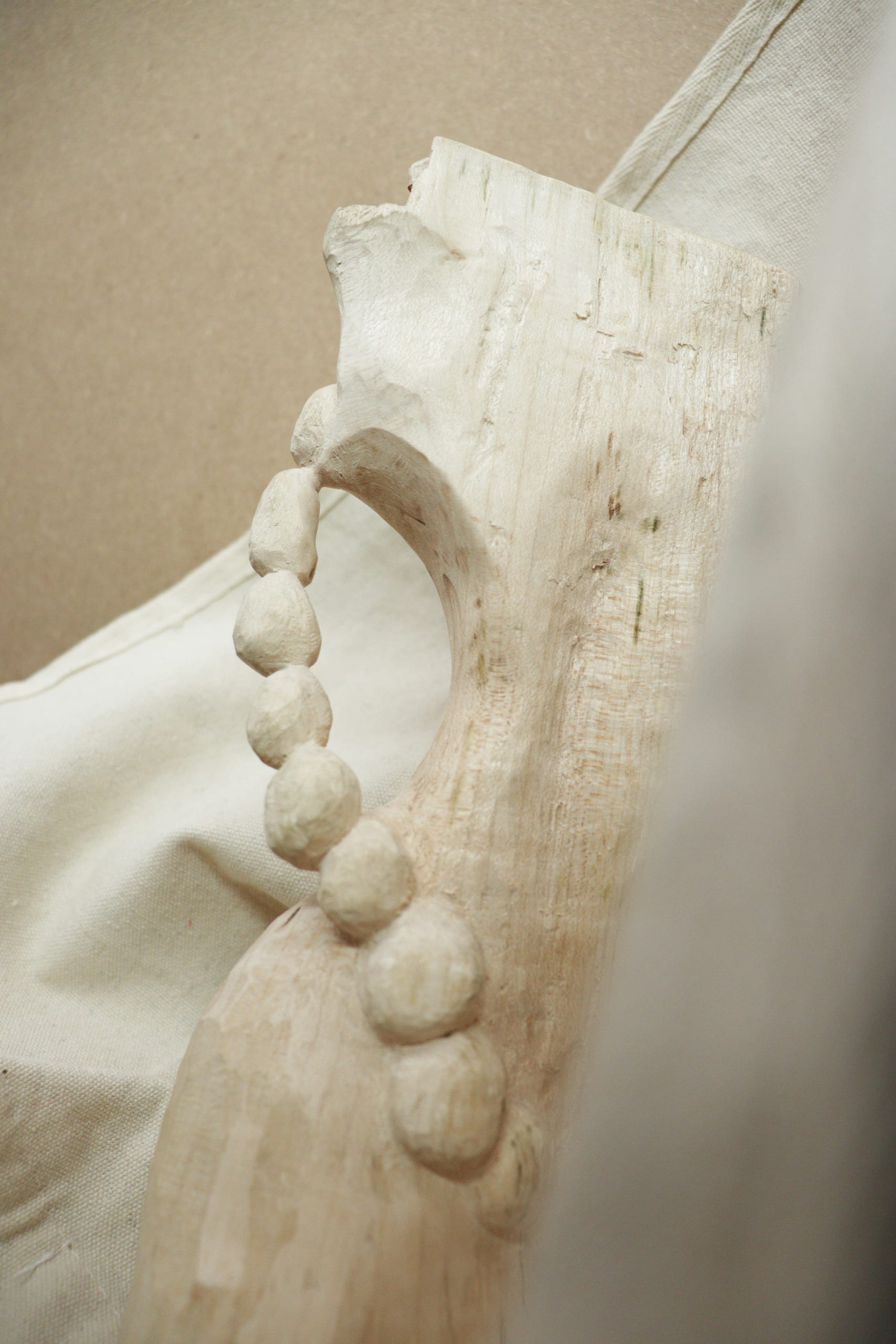 closer look of a block of wood hand-carved with pearl beads elements on 