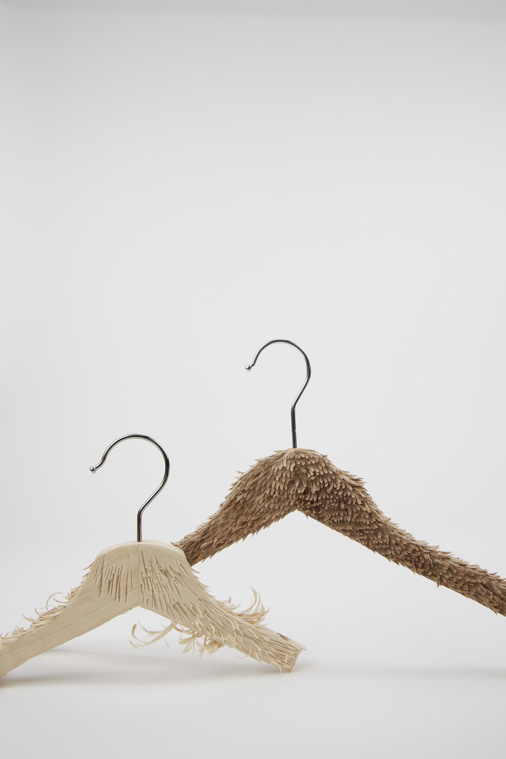 two furry hangers by using the carving tools to carve out little bits from flattened wooden surface.