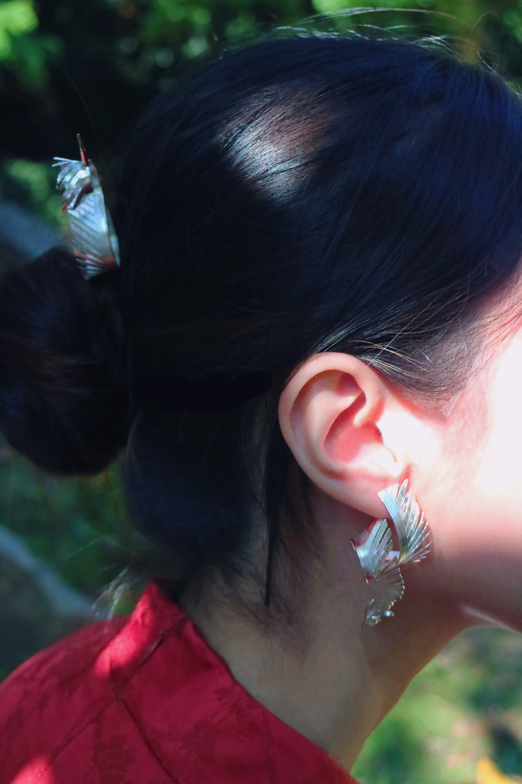 A picture of a model wearing a hair pin and earrings