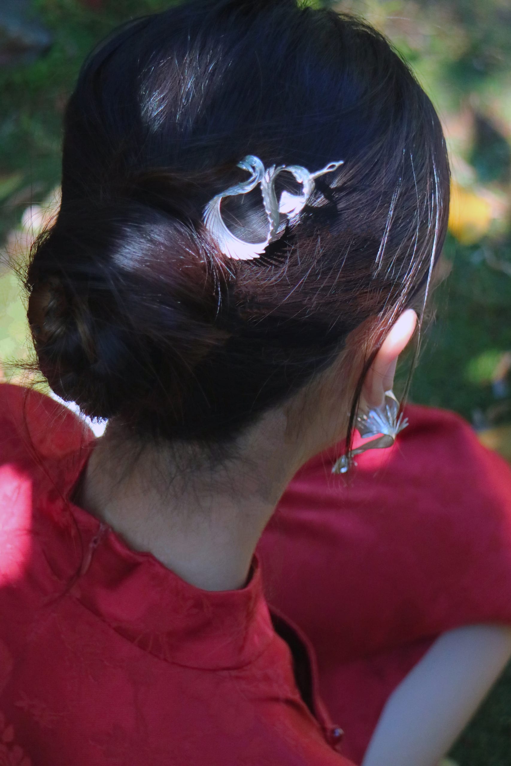 A picture of a model wearing a hair pin and earrings