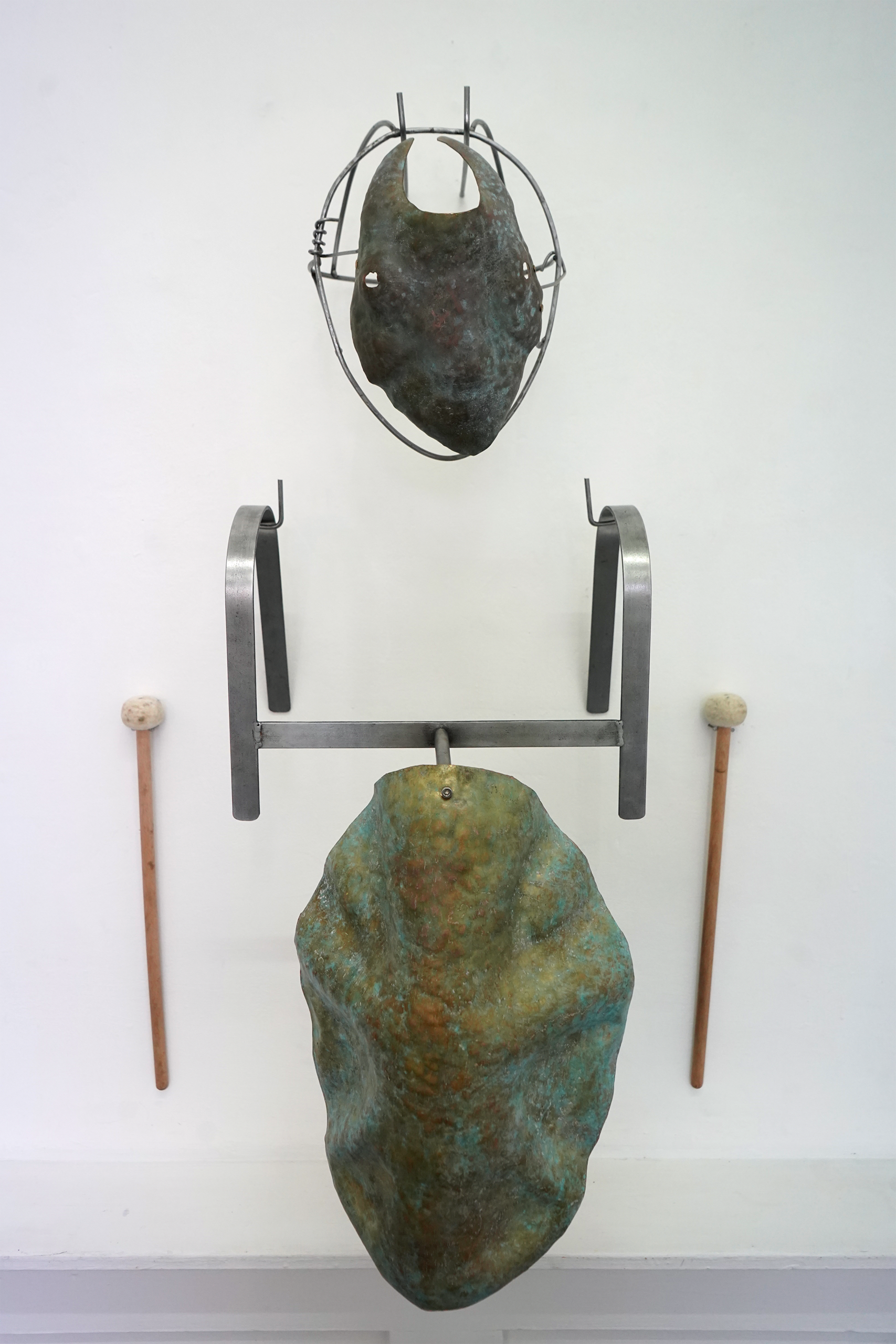 Metal costume, a mask and a drum that sits on the shoulders, mounted to a wall. 