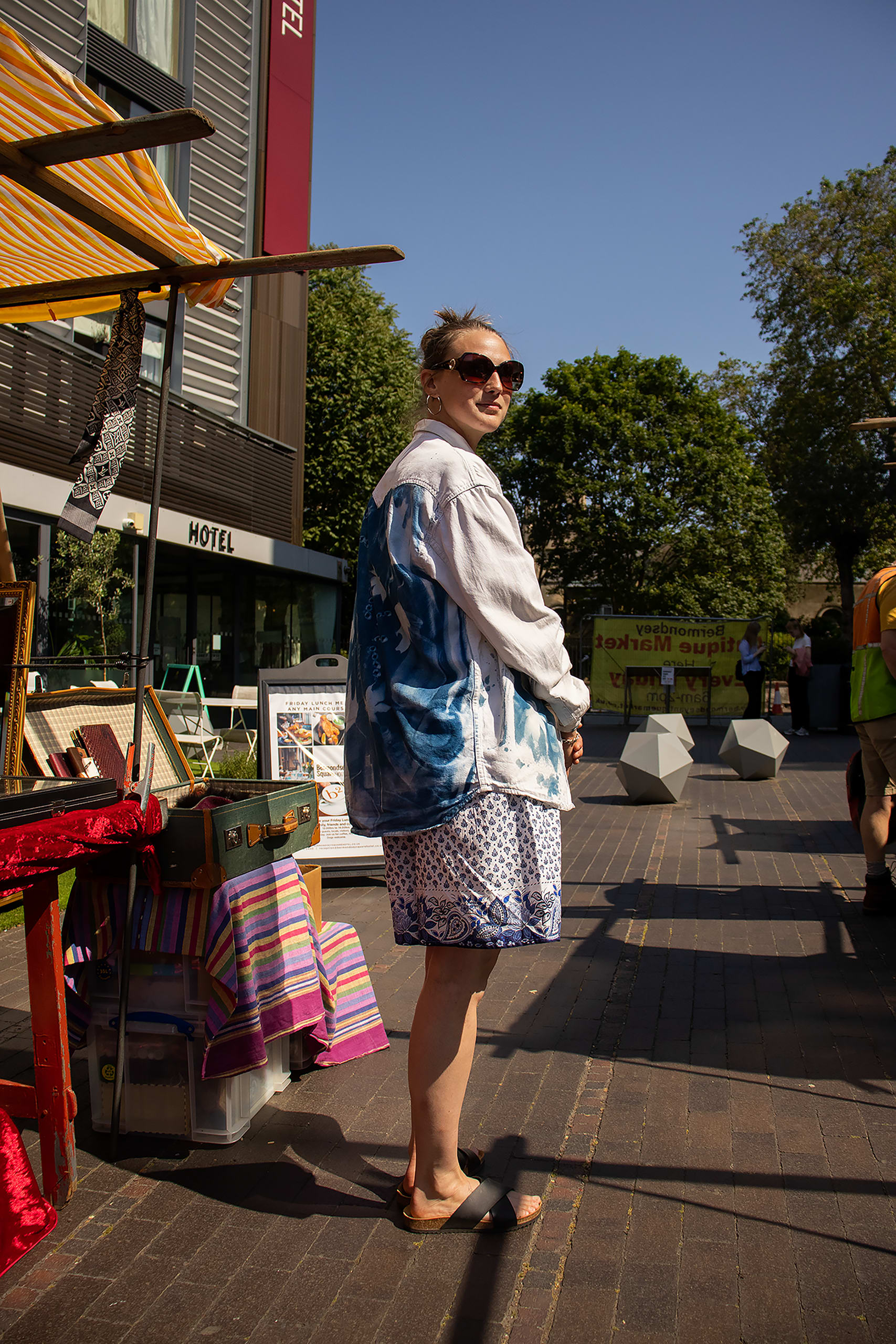 a lady stands posing to the camera showing off the back of her jacket that she has self printed with photosensitive ink