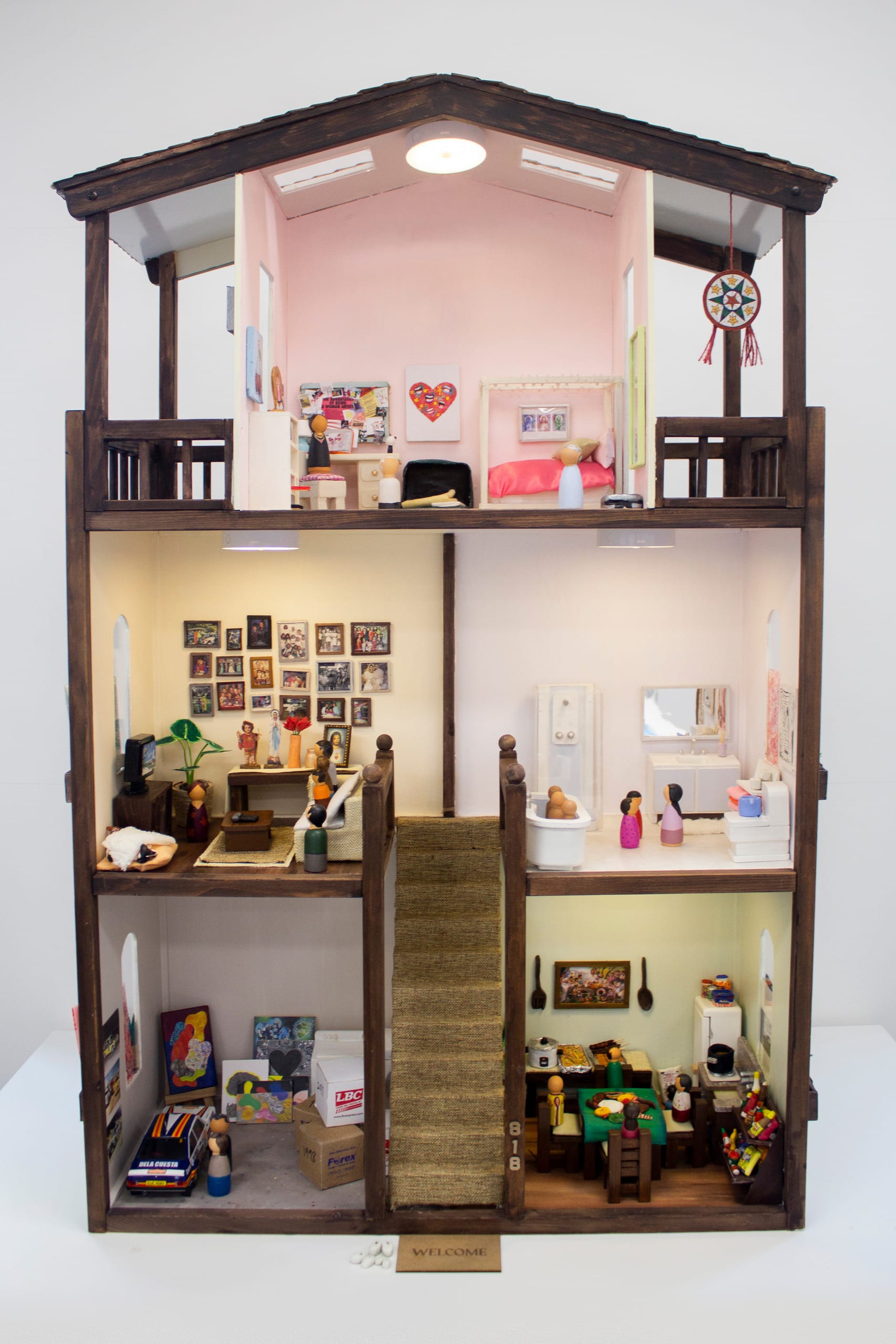 The image presents a refurbished second-hand, wooden dollhouse with three floors and five rooms.