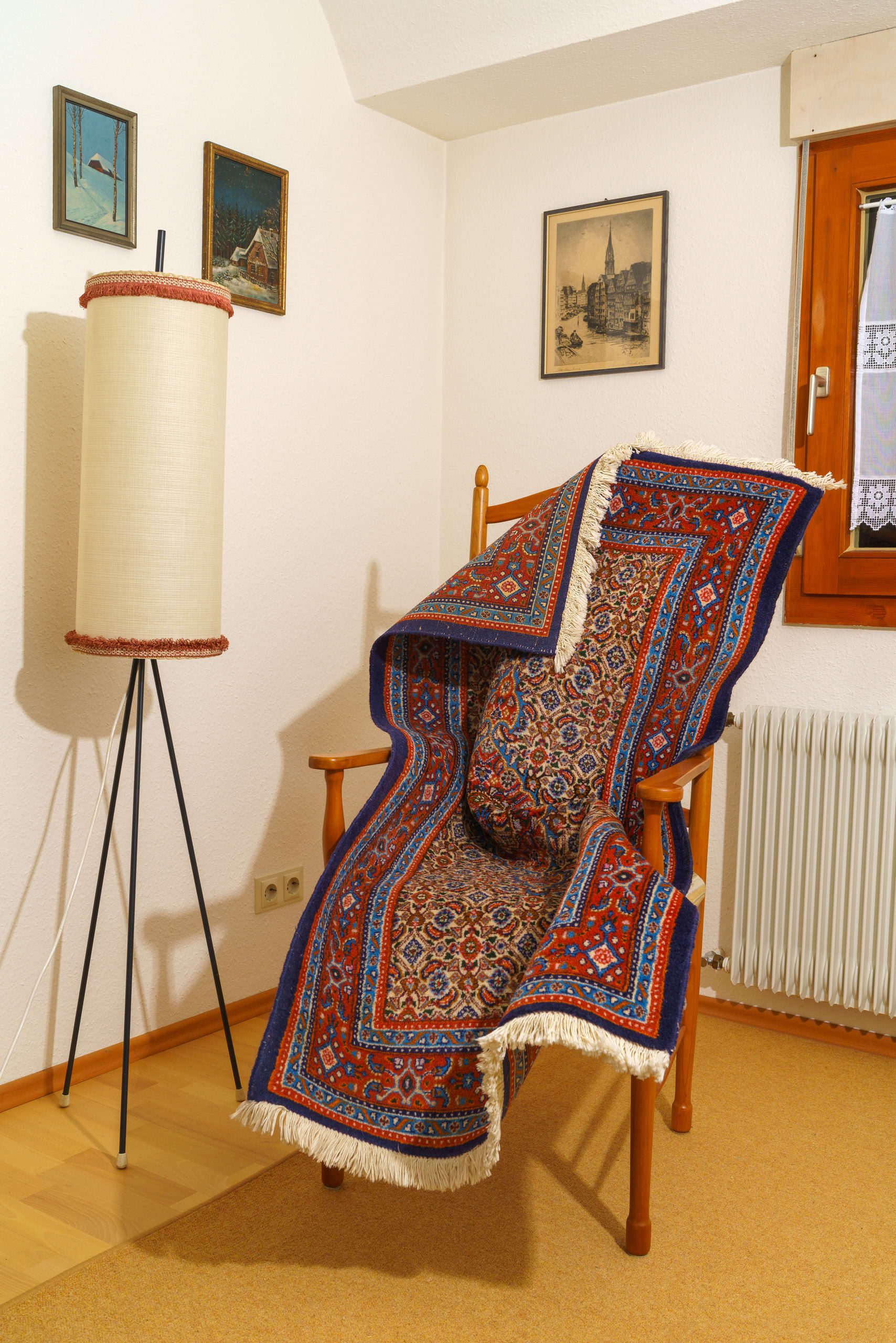 A rug positioned in a chair to look like a person.