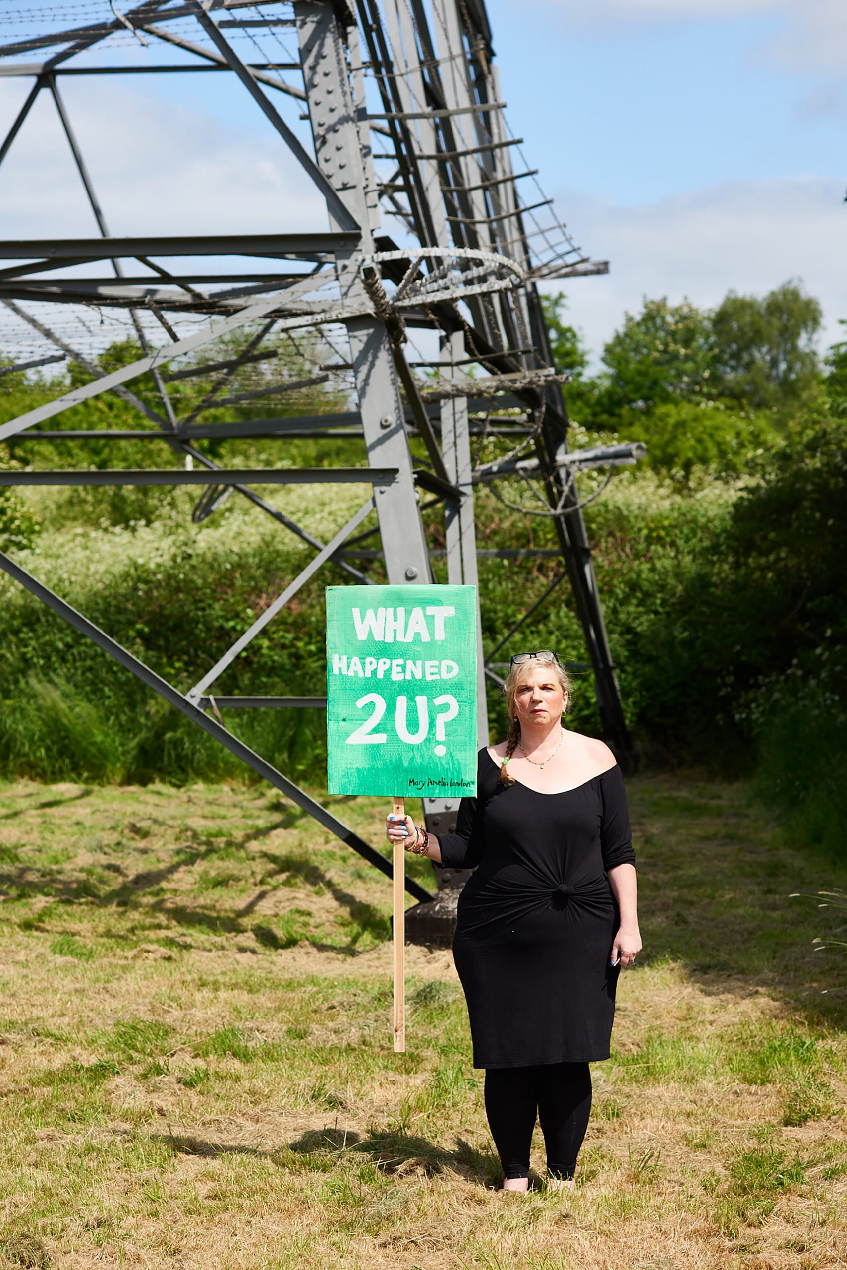 Mary Amelia London stands holding a sign saying: 'What happened 2 U?'