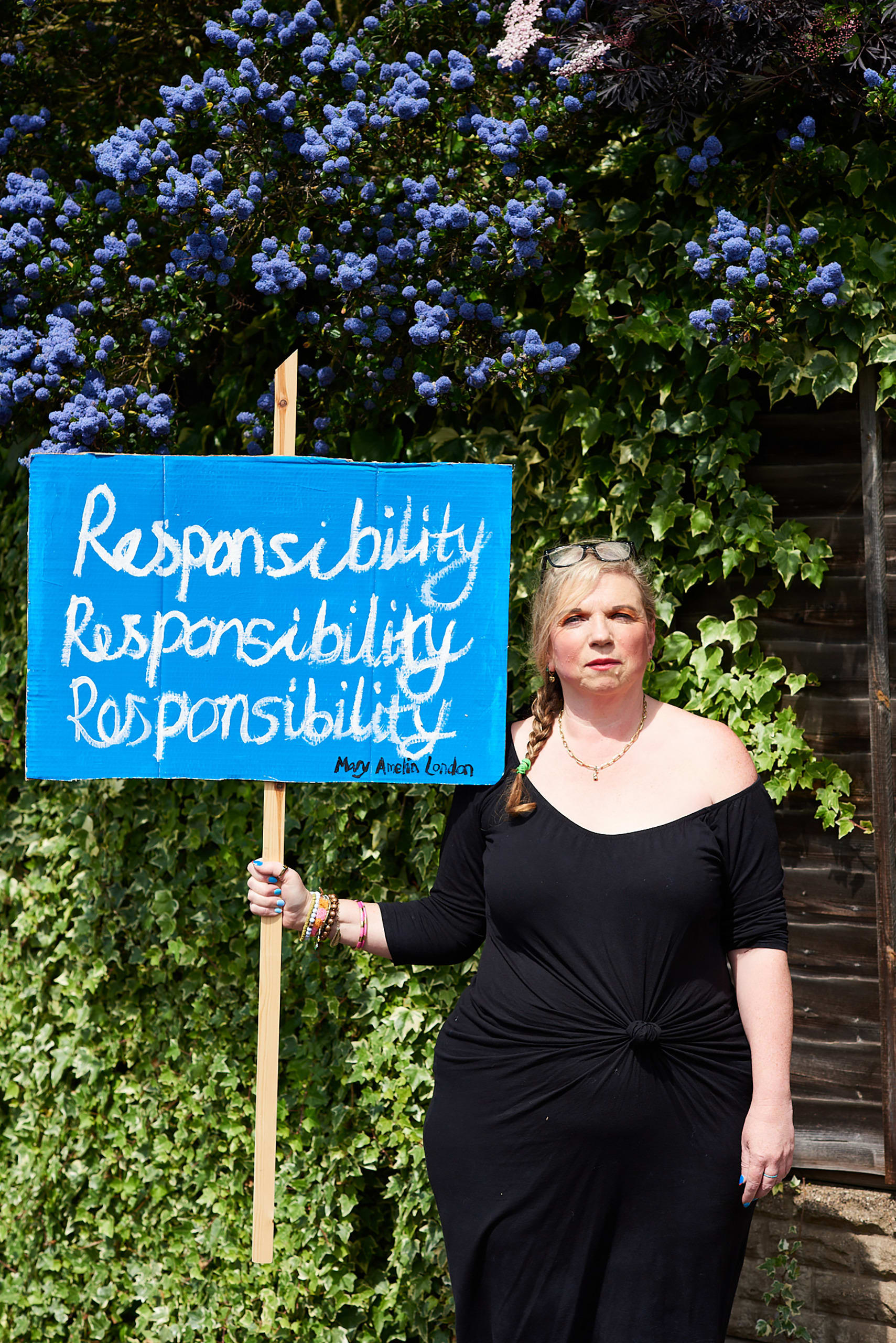 Mary Amelia London stands holding a sign saying: 'Responsibility. Responsibility. Responsibility'