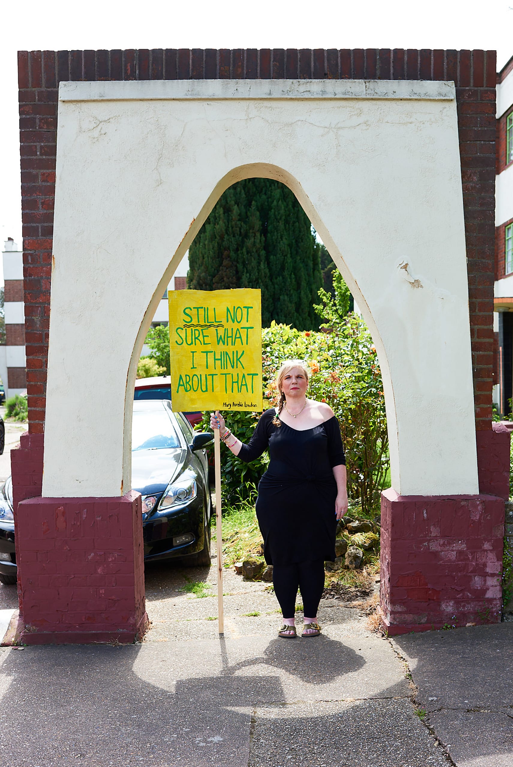 Mary Amelia London stands holding a sign saying: 'Still not sure what I think about that'