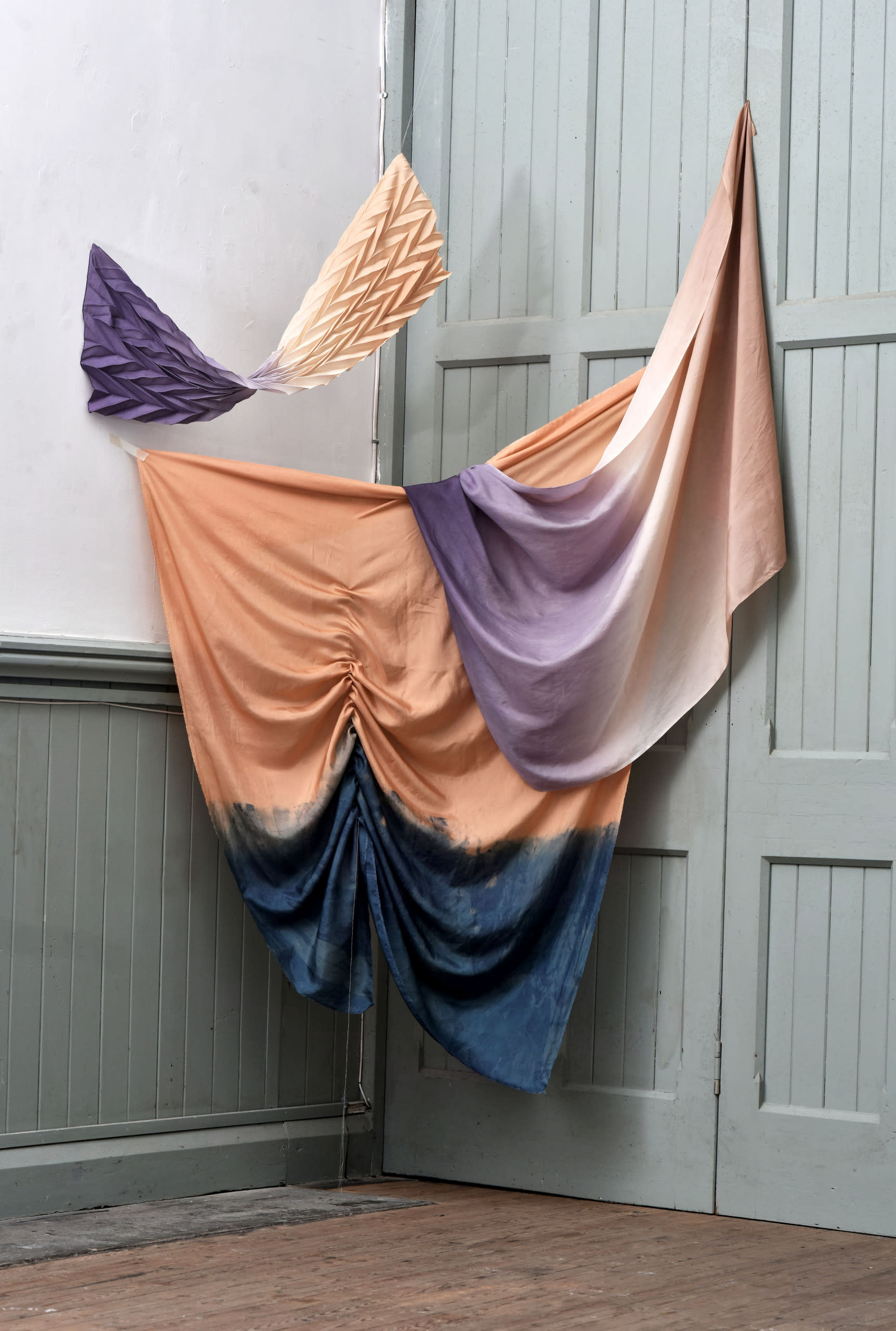 draped naturally dyed fabrics with pleated fabric in location space