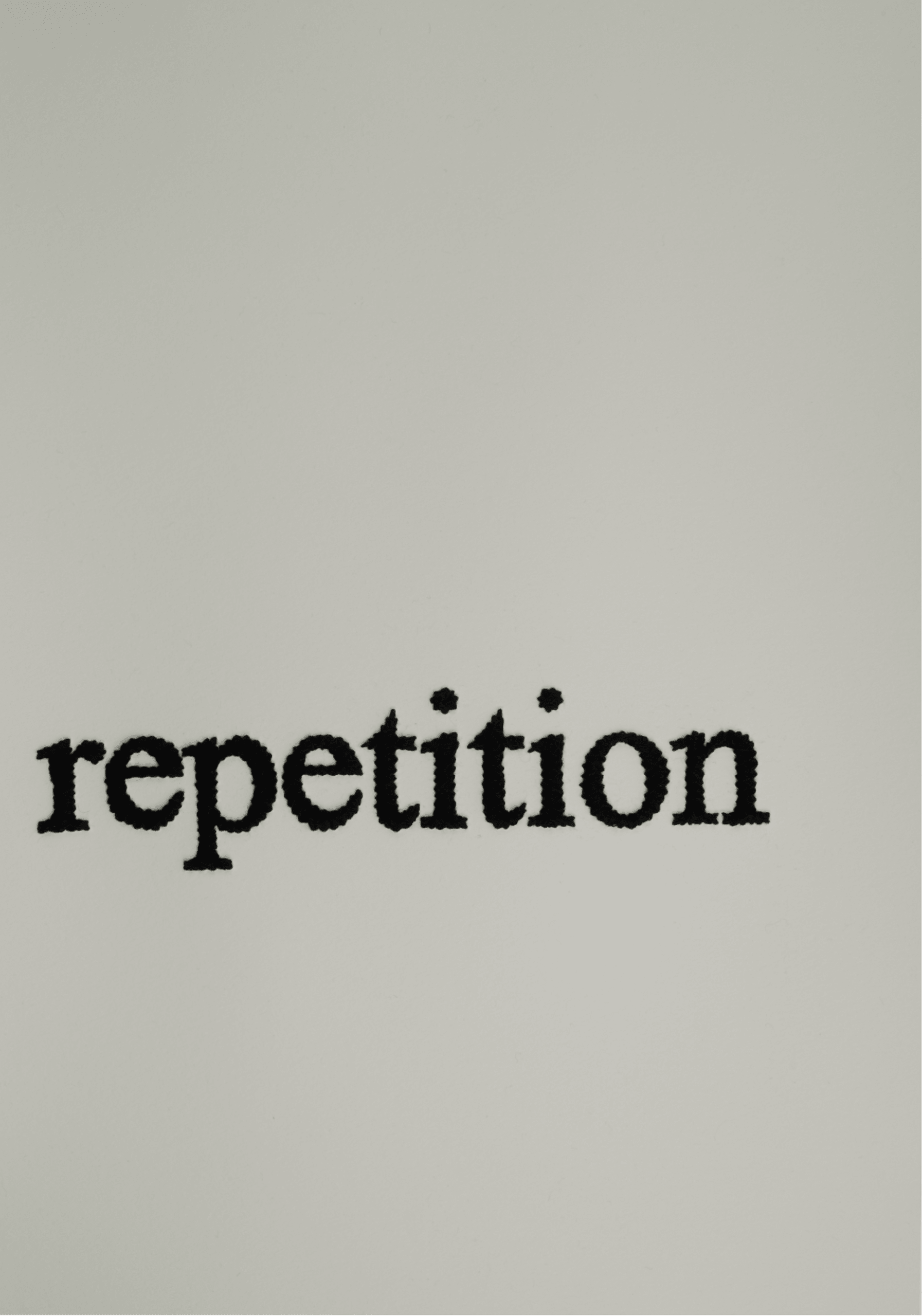 The word "repetition" embroidered on paper