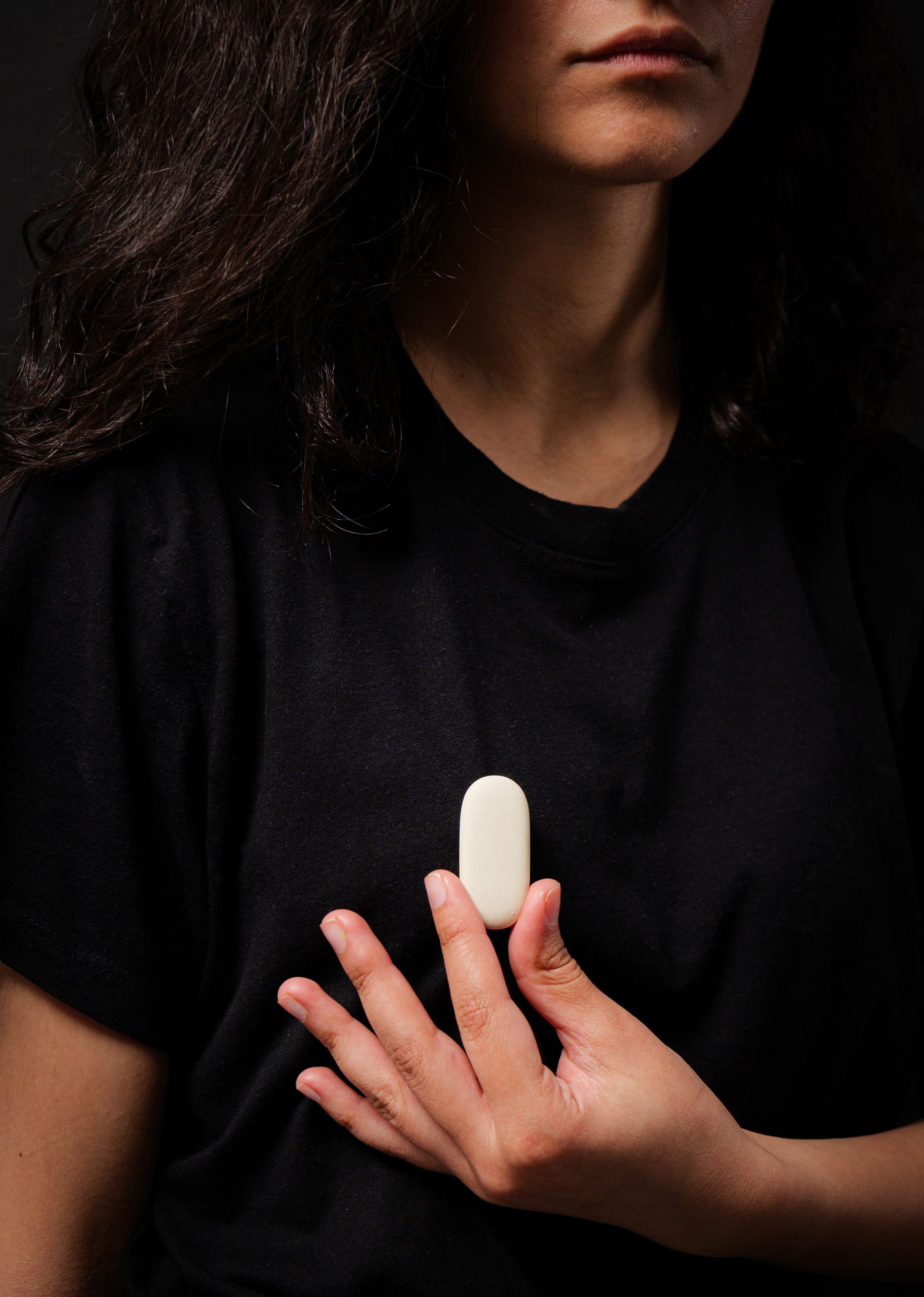 white oval eraser worn as a brooch