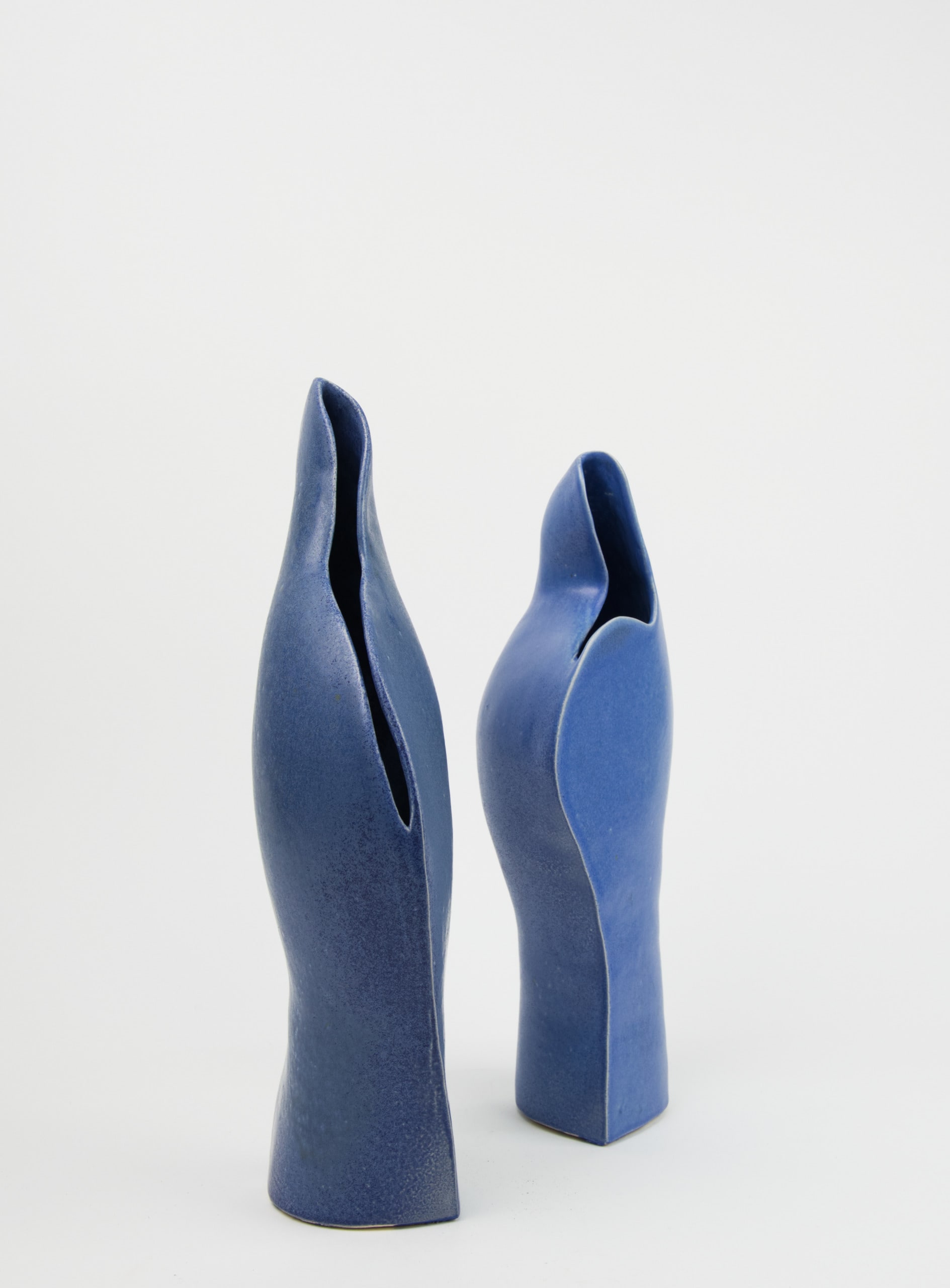 two blue curved ceramic vessels