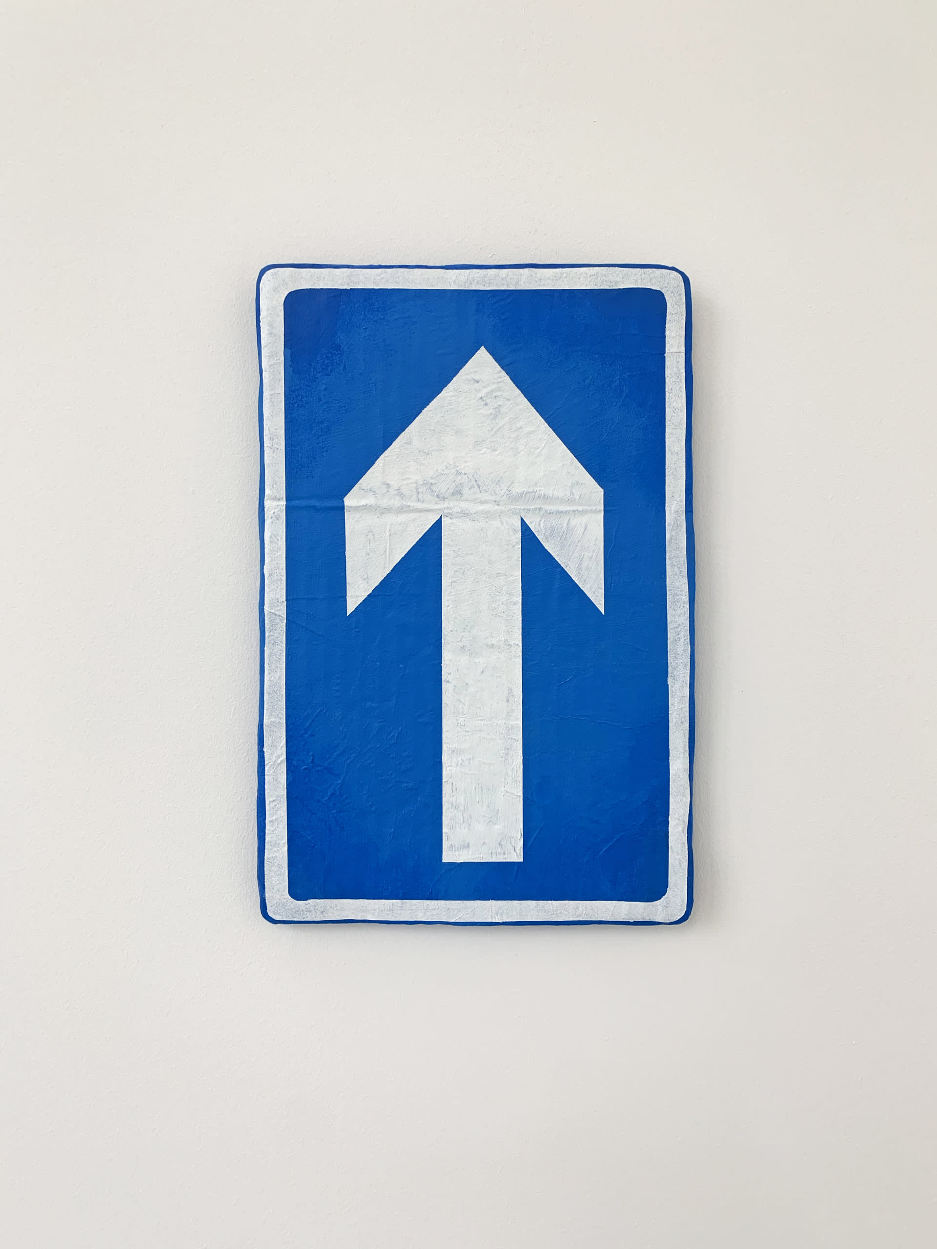 painting of a blue UK one way street sign on cardboard