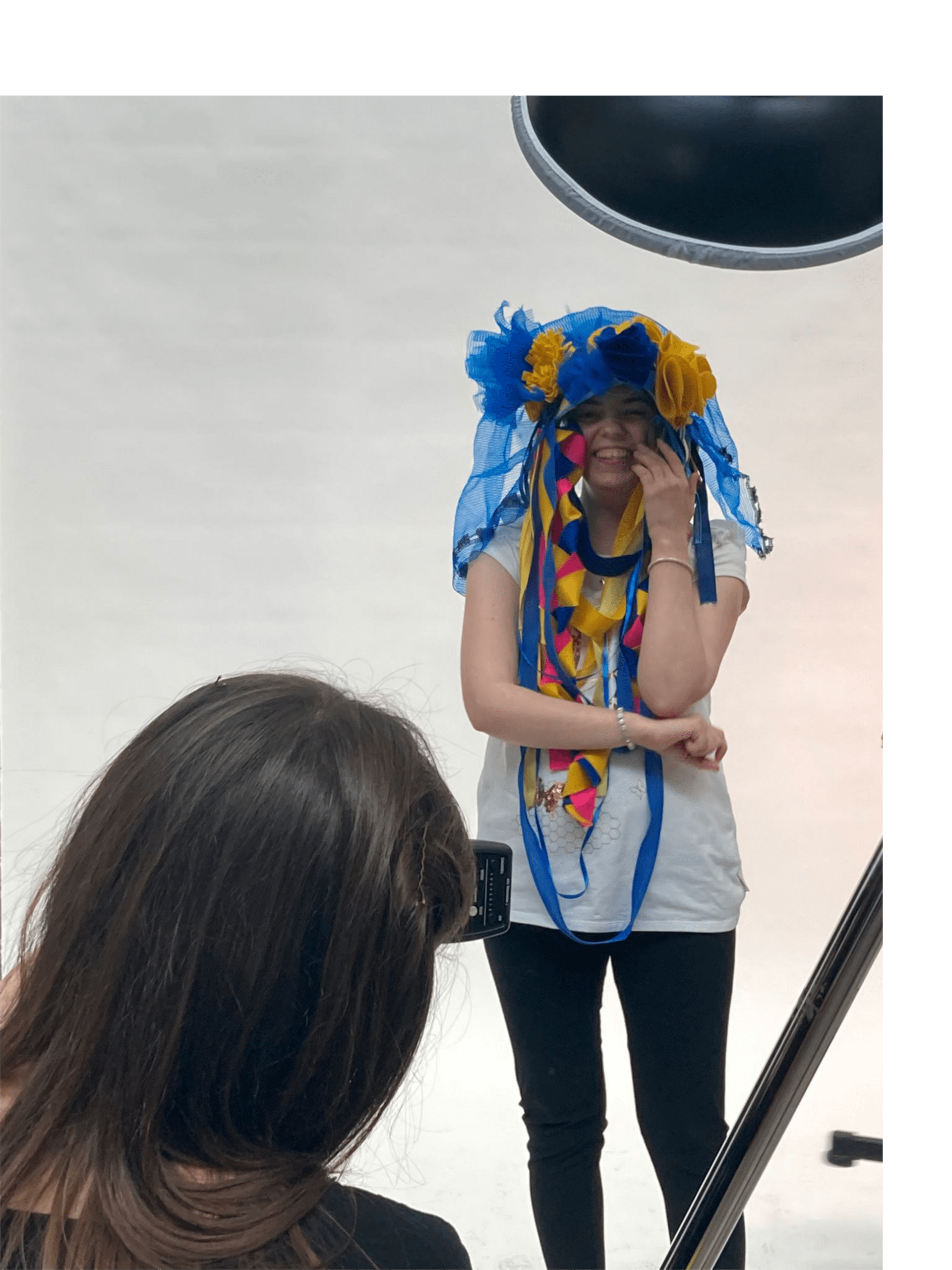 Wearing the blue and yellow hat Kelly has her photo taken by professional photographer Esme Moore in a white studio setting