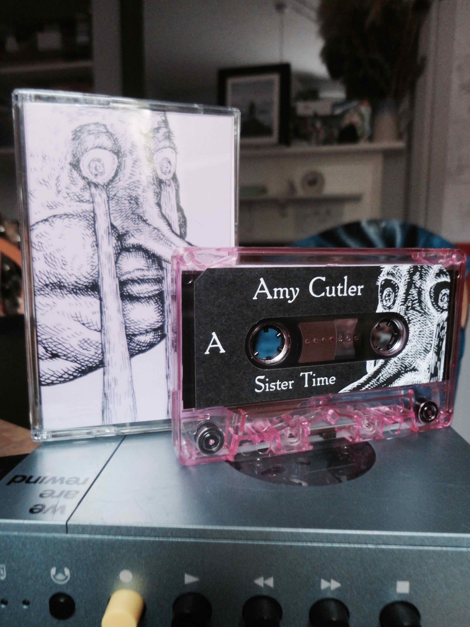 a translucent pink cassette tape printed with an illustration and the words Sister Time