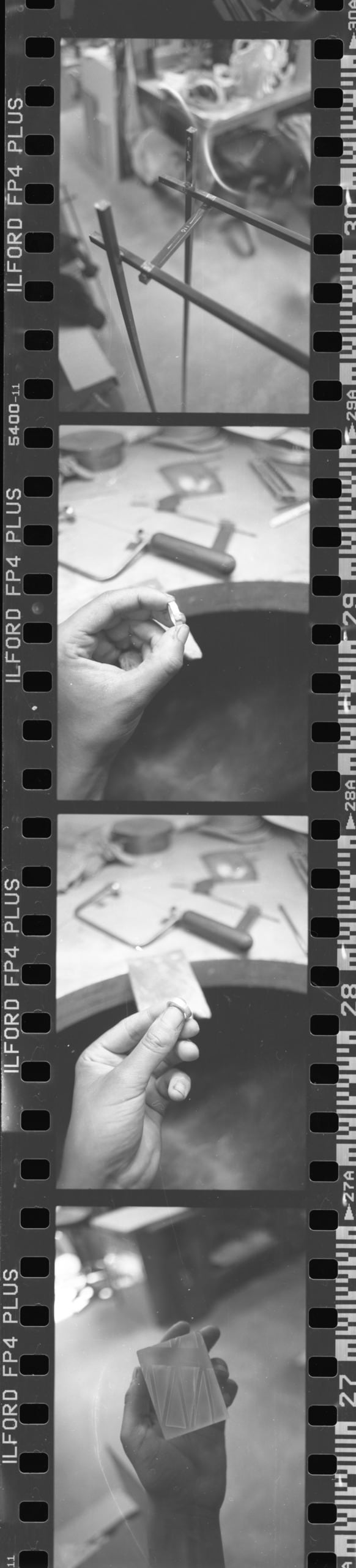 Scanned image of black and white negatives of work in progress shots, (silver ring making, metal working, pottery)