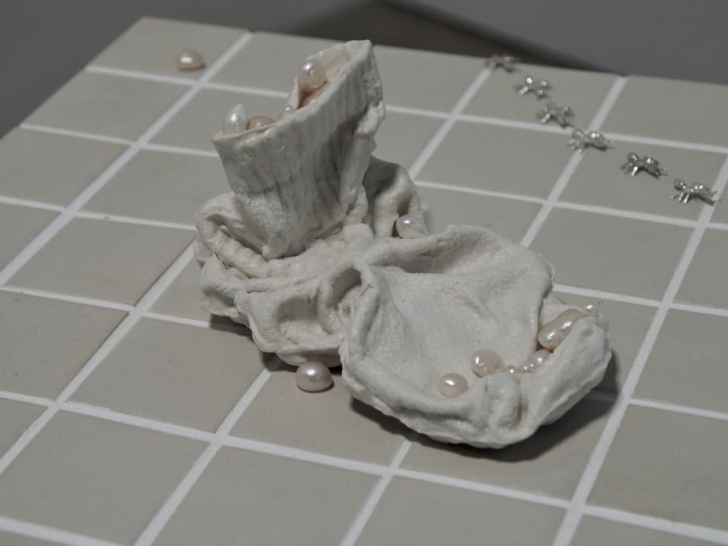 White ceramic sock filled with pearls, a trail of silver ants in the periphery 