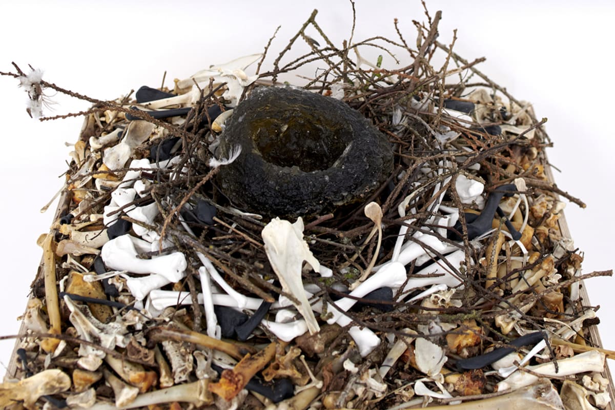 twigs, bones and bones made of black and white porcelain all intertwined, glass nest nestles in the middle