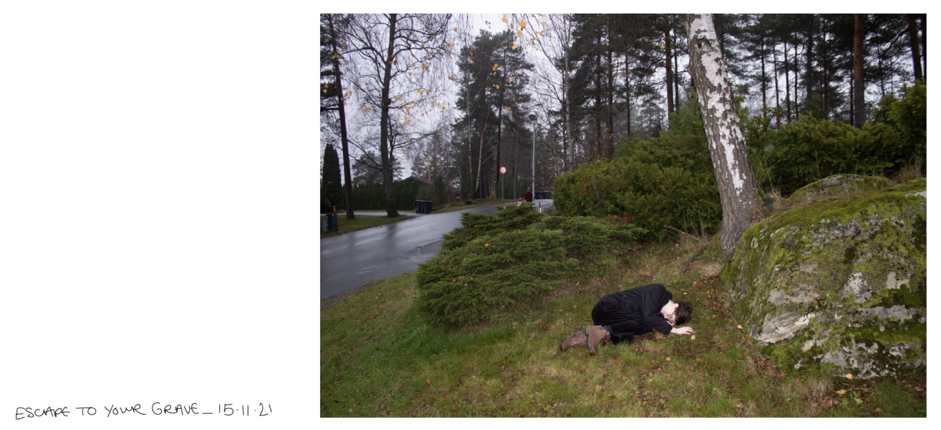 Person wearing all black curled up under a tree in a forest