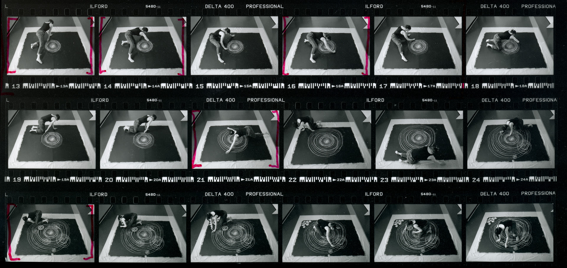 film contact sheet with annotations in red marker and images of the artist drawing with chalk in circles. 