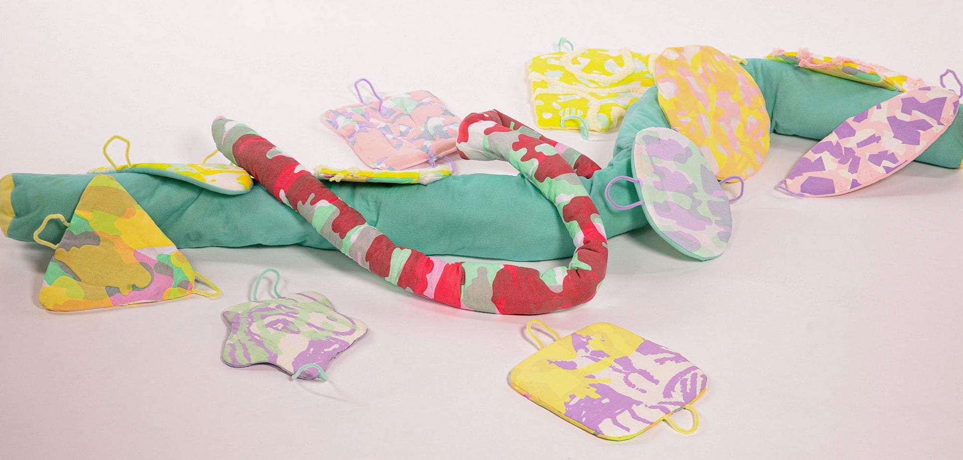 Multi-colour printed textile snakes and patches arranged in the white background. 
