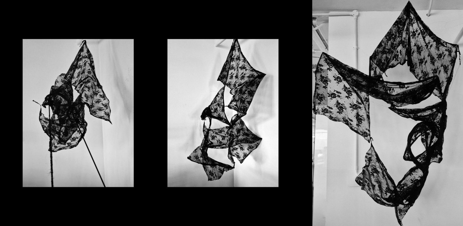 Three black lace sculptures, suspended in the air.