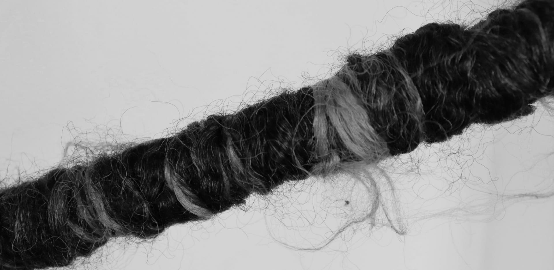 A pole wrapped in used protective style hairs.