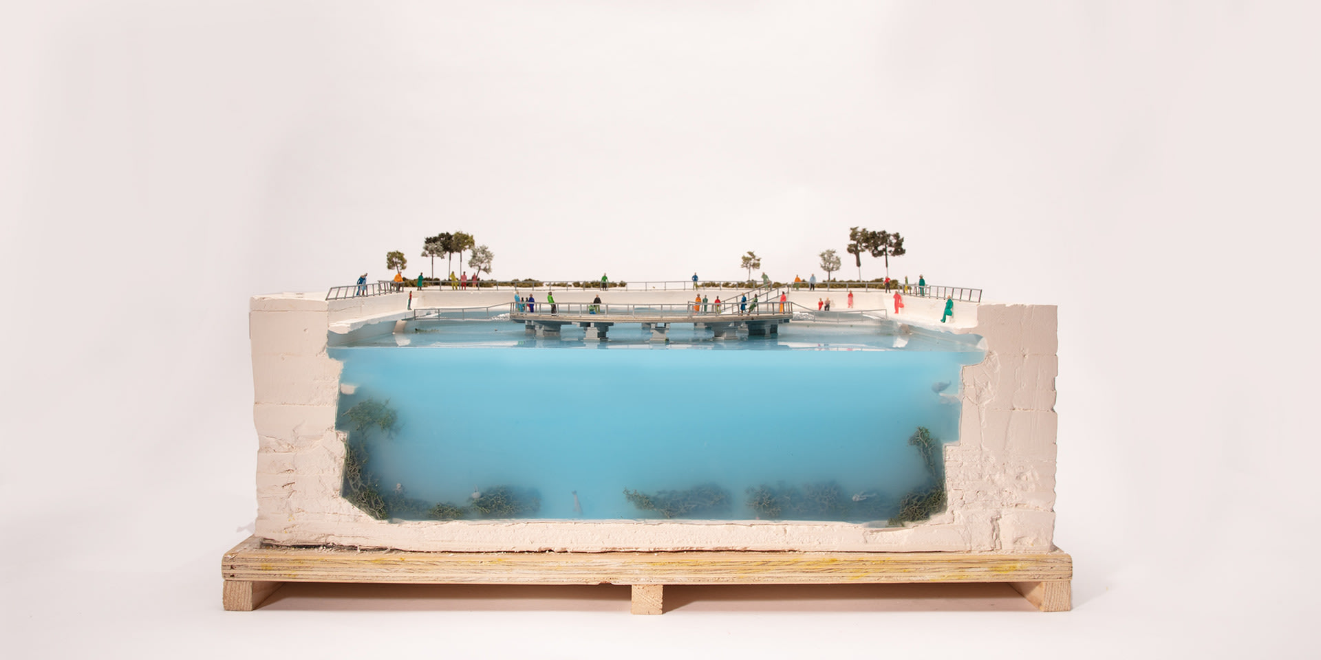 large-scale plaster and blue silicone model showing a sectional view of the stage. Colourful people dot are scattered over the model