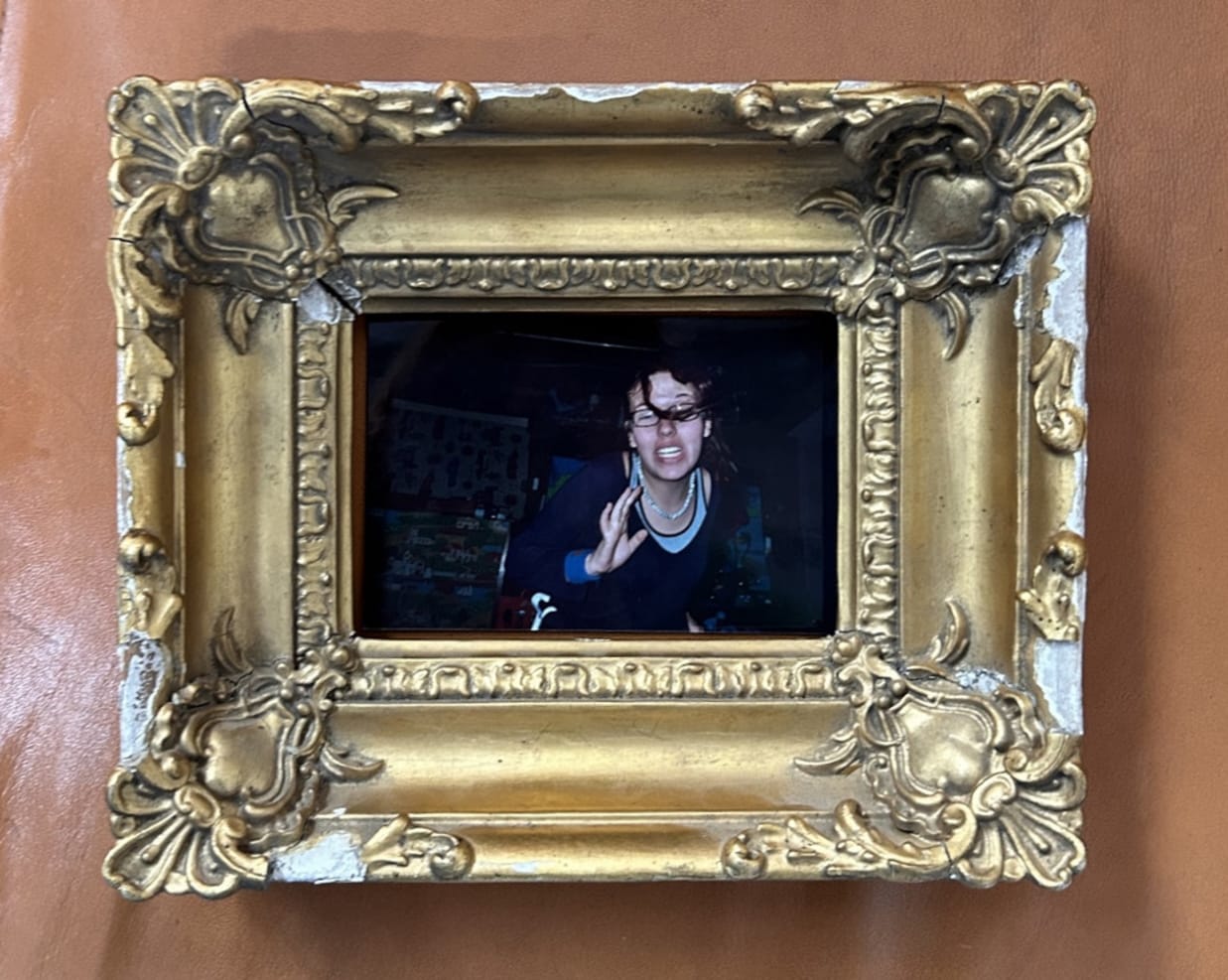 Image of the artist as a teenager from a family photo album in a small but ornate golden frame