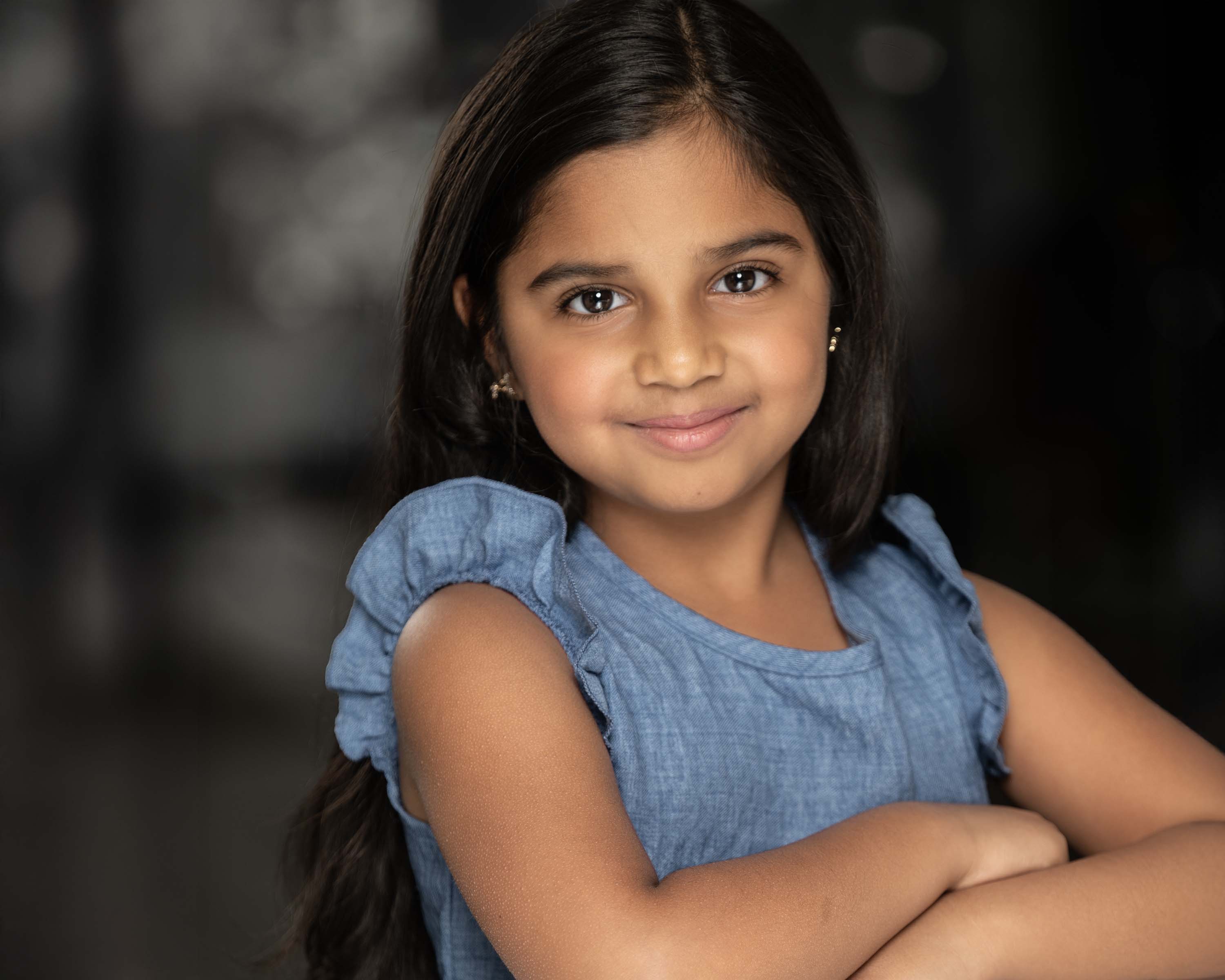 Natasha smiling in a blue denim dress