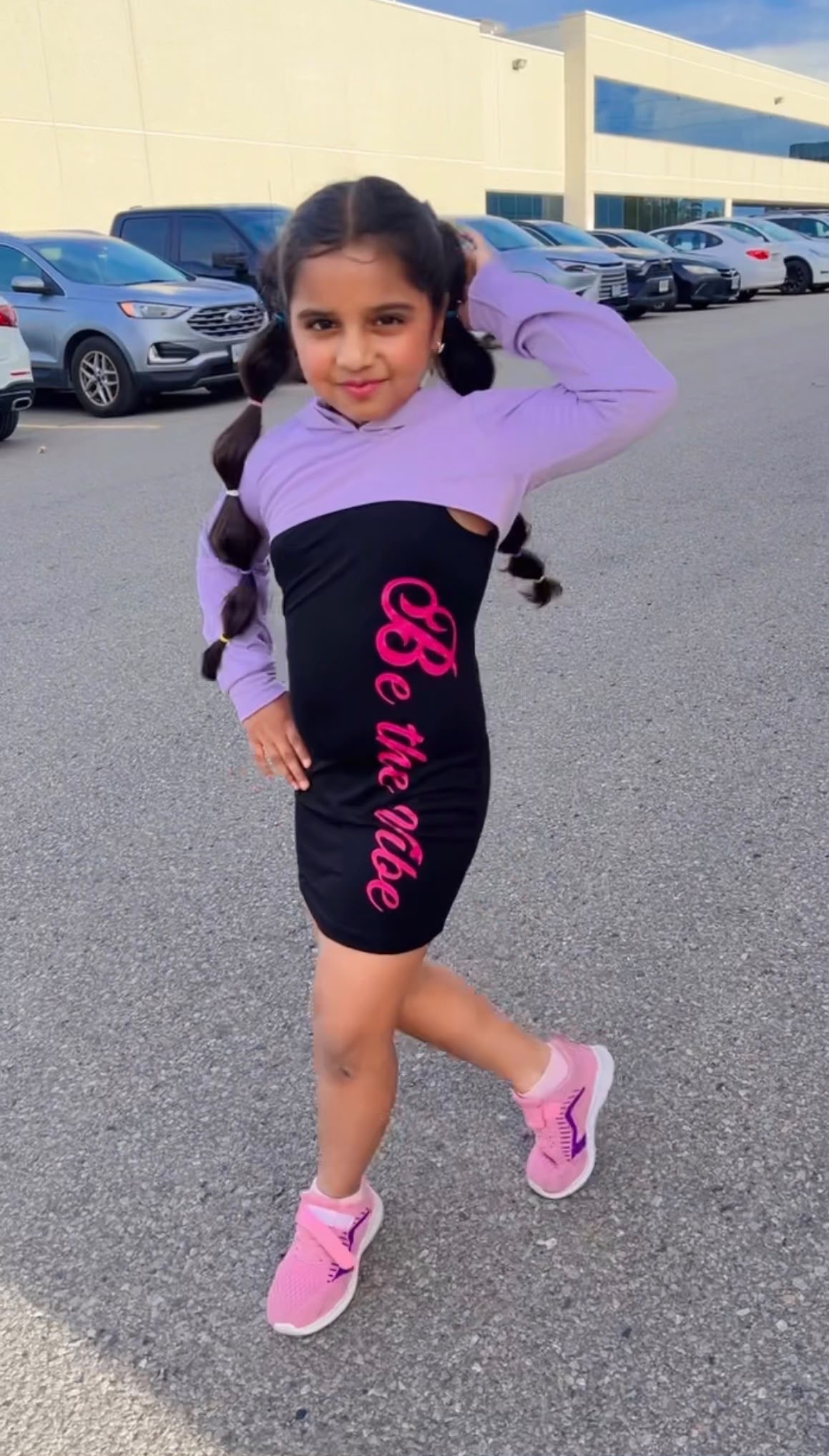 Natasha posing outdoors in a purple and black outfit