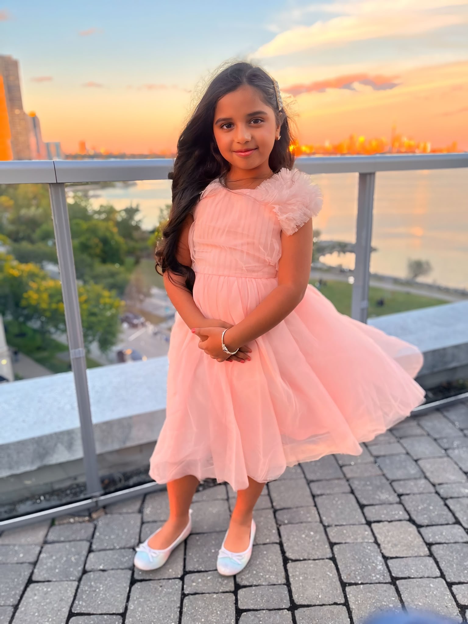 Natasha in a pink dress with the sunset behind her