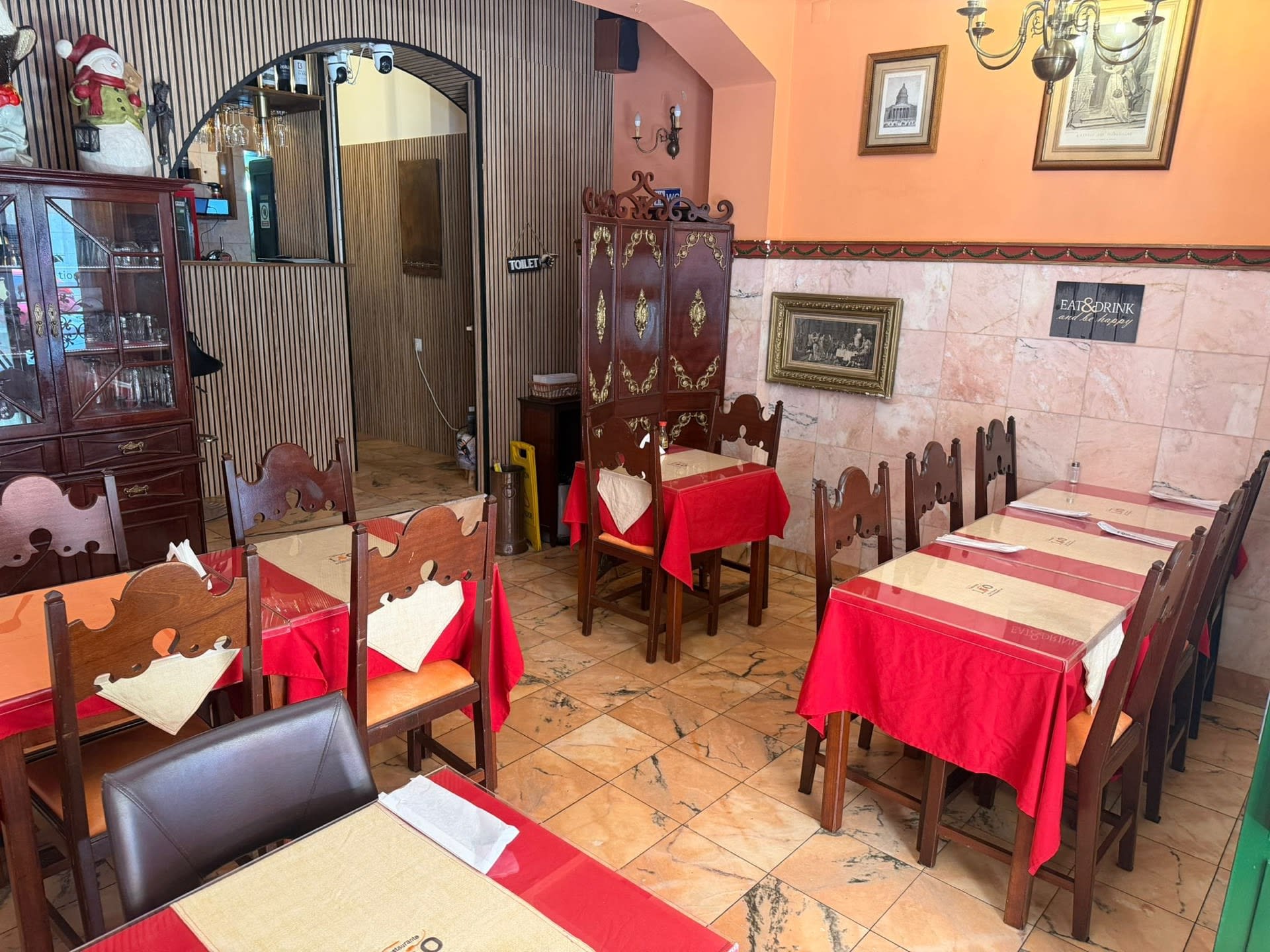 Dining room with carved wooden chairs and a gilded wooden screen