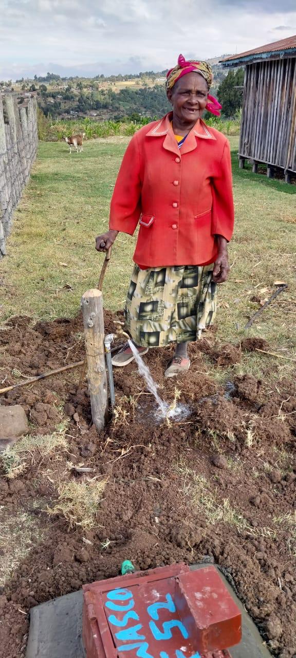 Woman with shovel at well site