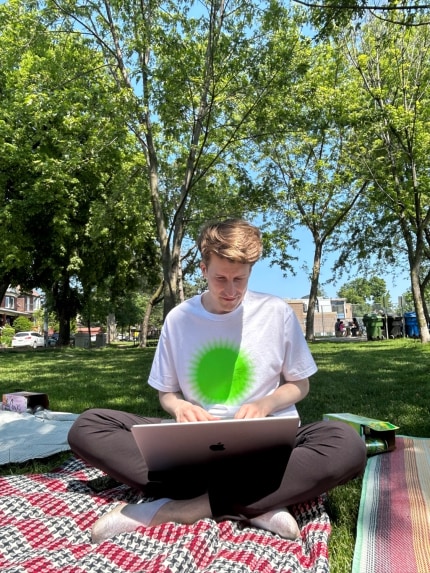 ross sitting cross legged on a blanket wearing a html energy shirt