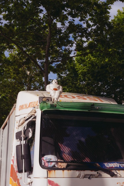 Front view close-up of a truck. On top of the windshield there's a little Michelin Man figure with a light in his chest.