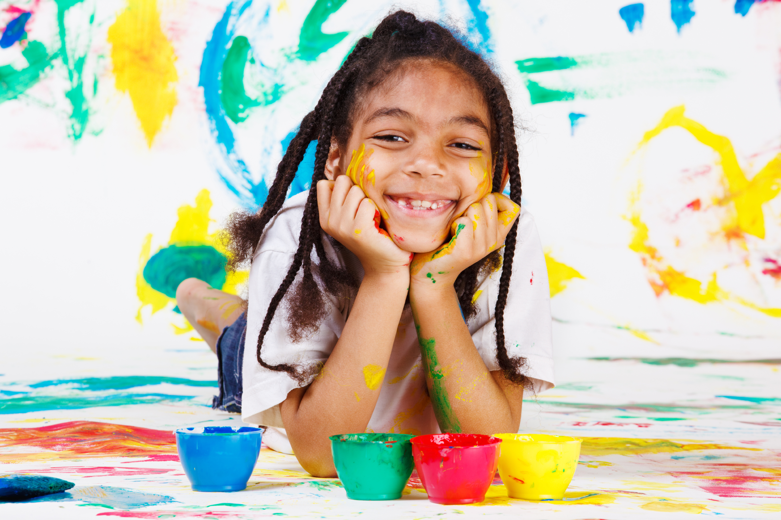 African American kid playing with finger paints