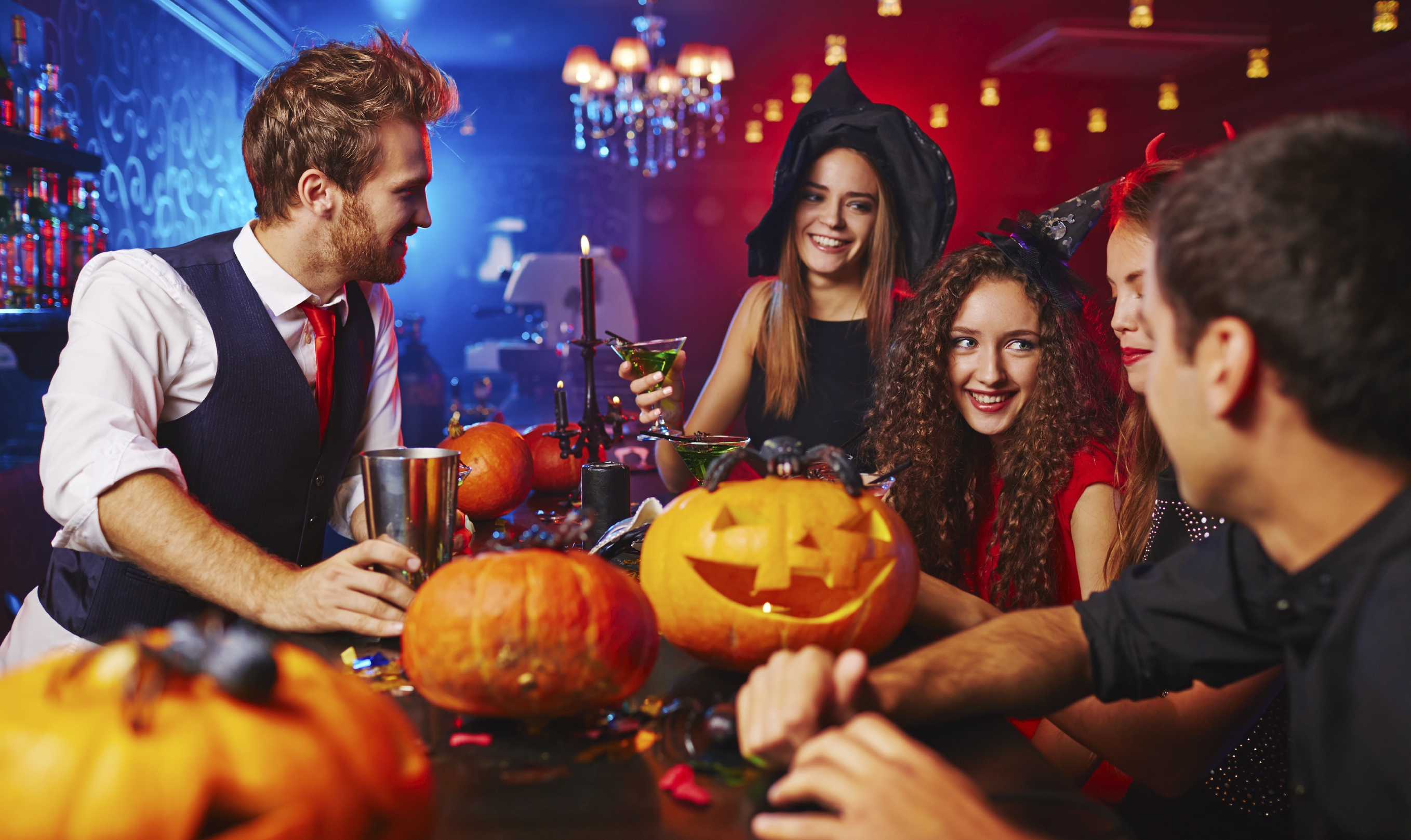 Happy witches celebrating Halloween in bar