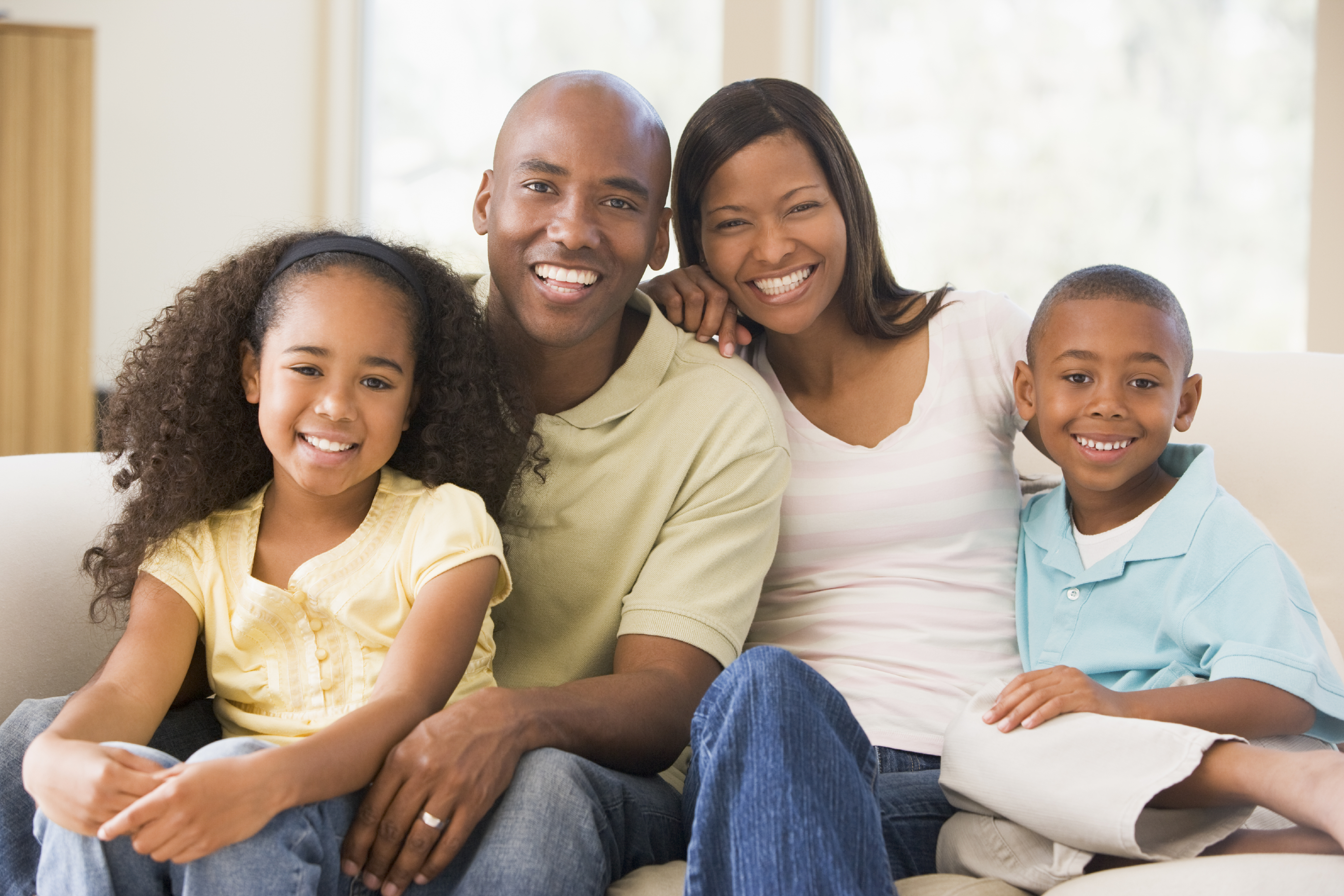 Family sitting in living room smiling