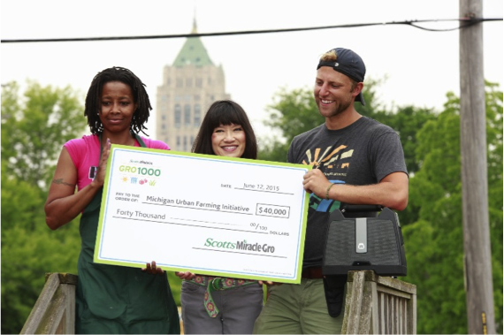 Su Lok, Director, Corporate and Community Partnerships presents a $40,000 grant from ScottsMiracle-Gro to Michigan Urban Farming Initiative Co-Founder and President, Tyson Gersh and Farm Manager, Pinky Jones during the GRO1000 event.