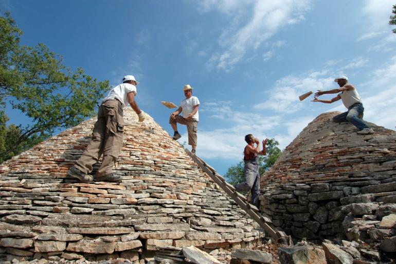 People building Kažun dry stone wall shelter in Croatia