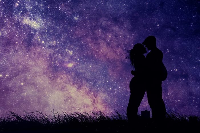 Couple embracing with starlight in the background