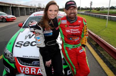 Man and women standing in front of a V8 supercar