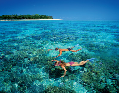 Two people snorkelling over the Great Barrier Reef