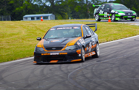 Man standing in front of V8 race car