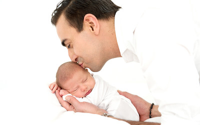 Dad kissing newborn baby