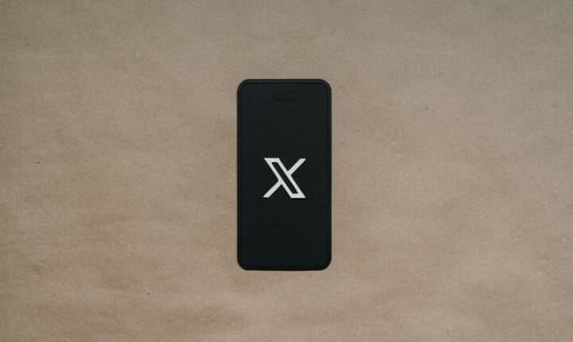 black phone displaying "x" logo