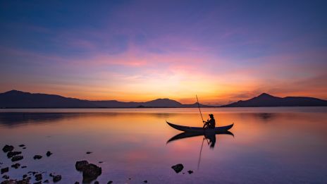 Stilla faller regnets droppar på vattnet, mellan månljus och solsken.